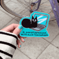 Kissa-aiheinen kangasmerkki jossa kissa istuu tietokoneella